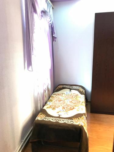 a small bed in a room with a window at Tatev Apartments in Yerevan