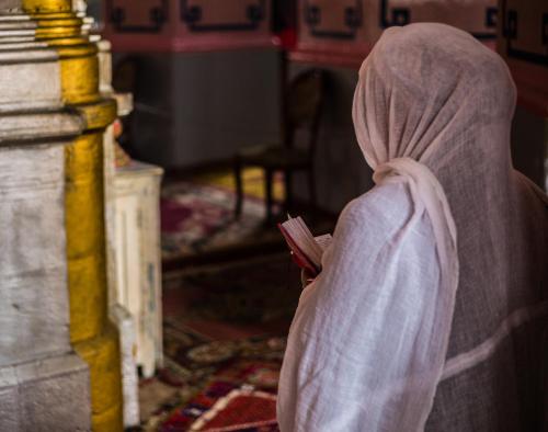 a person wrapped in a blanket holding a cell phone at Villa Brown Jerusalem, a member of Brown Hotels in Jerusalem