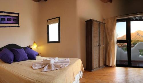 a bedroom with a bed with towels on it at Cabanas Las Maras in Capilla del Monte