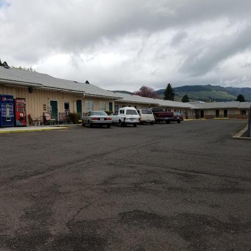 a parking lot with cars parked in front of a motel at Greenwell Motel in La Grande