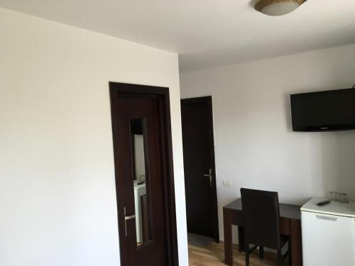 a room with a desk and a table and a television at Vila DG in Mamaia Nord