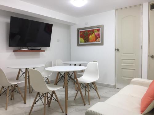 a living room with a table and chairs and a tv at Plaza Mayor Lima in Lima