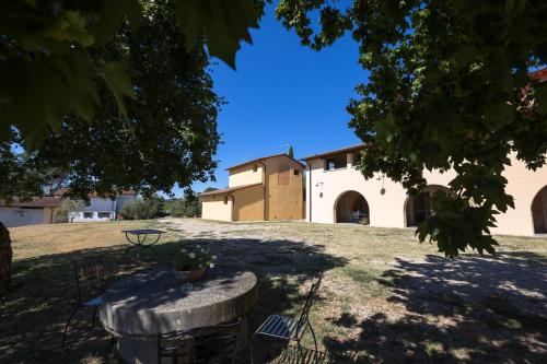 uma vista para um edifício com uma mesa num quintal em Agriturismo Lo Zolfino em Terranuova Bracciolini