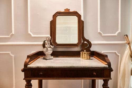 a dressing table with a mirror and a vase on it at Ale & Niki's Home in Rome
