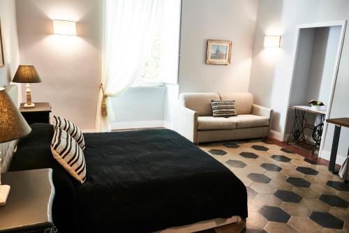 a bedroom with a bed and a couch and a chair at Ale & Niki's Home in Rome