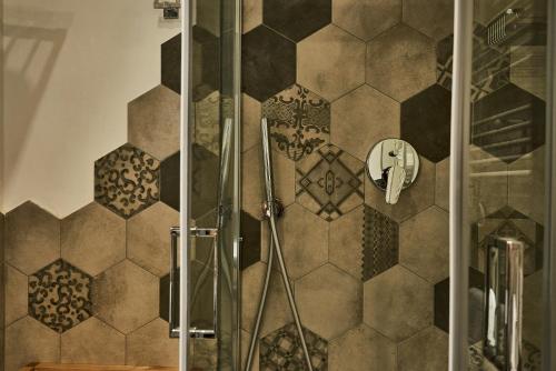 a bathroom with a shower with a tiled wall at Ale & Niki's Home in Rome