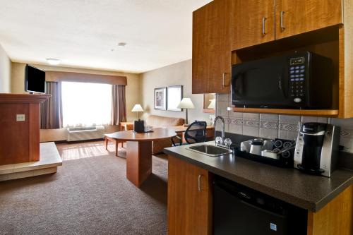 a hotel room with a kitchen and a living room at Canalta Brooks in Brooks