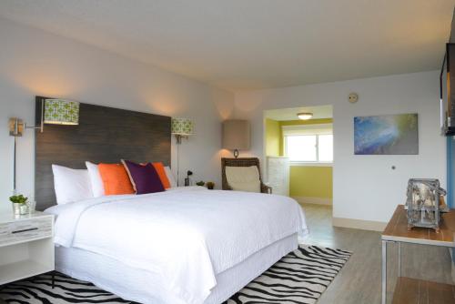 a bedroom with a large white bed and a desk at Beach House Dewey in Dewey Beach
