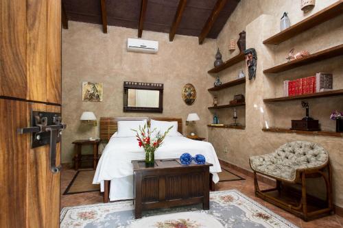 a bedroom with a bed and a table and a chair at Hacienda San Gabriel de las Palmas in Amacuzac