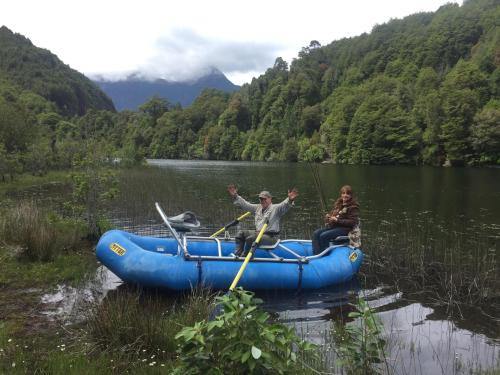 a man and a woman in a raft on a lake at Casa Campo Carretera Austral in Puerto Cisnes
