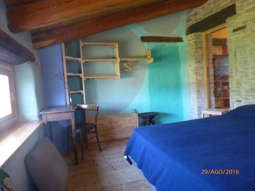 a bedroom with a bed and a desk and a table at Casa della Casa in San Severino Marche