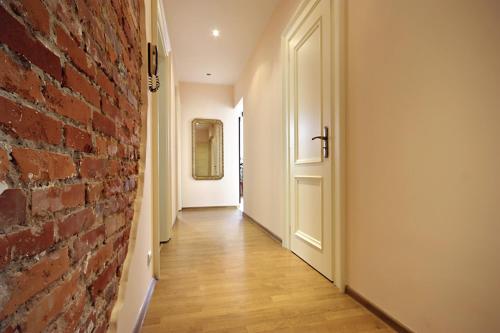 a hallway with a red brick wall and a white door at Kwatera Prywatna Maja in Sopot