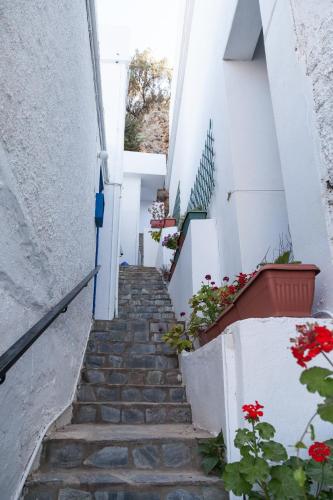 a stairway with red flowers and white buildings at Loutro Holidays in Loutro