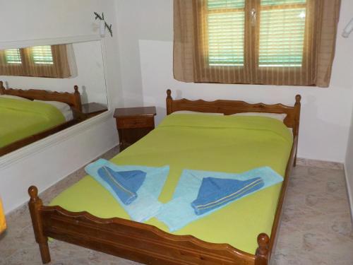a bedroom with a green bed with blue sheets at Azalea in Megali Ammos
