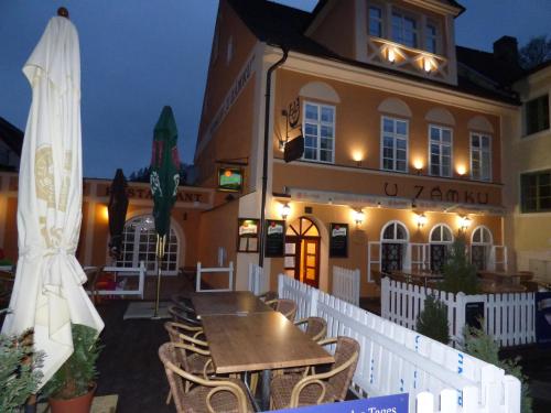 a restaurant with a table and chairs in front of a building at Penzion - Restaurant U Zámku in Bečov nad Teplou