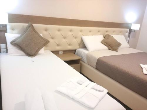 a hotel room with two beds and a mirror at Kanali Studios in Parga