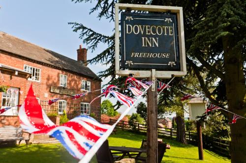a sign in front of a house with american flags at Dovestays in Laxton