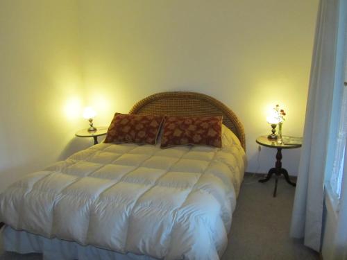 a bedroom with a bed and two tables with lamps at Hacienda Santa Clara in Peumo