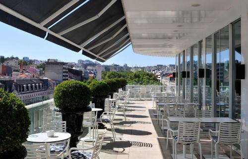 a row of tables and chairs on the roof of a building at Altis Avenida Hotel in Lisbon