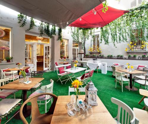 restauracja ze stołami, krzesłami i czerwonym parasolem w obiekcie Hotel Vittoria w mieście Faenza