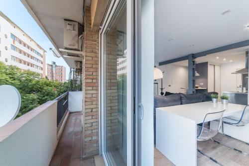 a kitchen and living room with a balcony with a table at Apartamento Luis de Vargas in Huelva