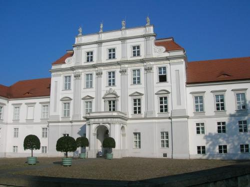 ein großes weißes Gebäude mit rotem Dach in der Unterkunft Andersen Hotel Birkenwerder in Birkenwerder