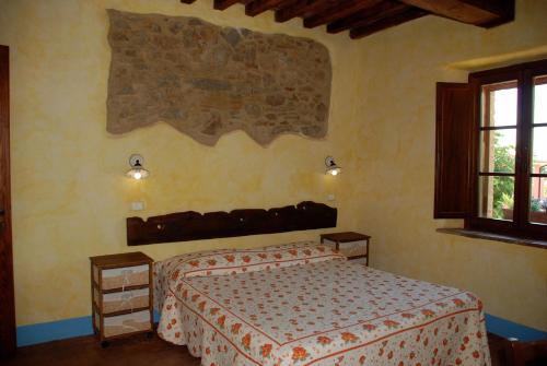 1 dormitorio con cama y ventana en La Mulattiera, en Scarlino