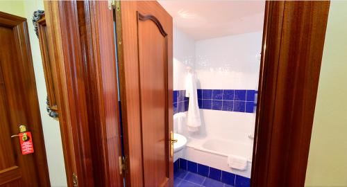 a bathroom with a tub and a toilet and a sink at Hostal Bar Stop in Velilla del Río Carrión