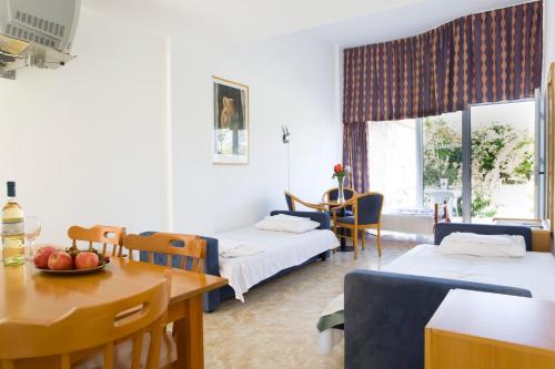 a hotel room with two beds and a table and chairs at Eliofos Elegant Maisonettes in Polis Chrysochous