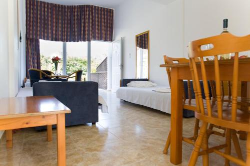 ein Wohnzimmer mit einem Bett, einem Tisch und Stühlen in der Unterkunft Eliofos Elegant Maisonettes in Polis Chrysochous