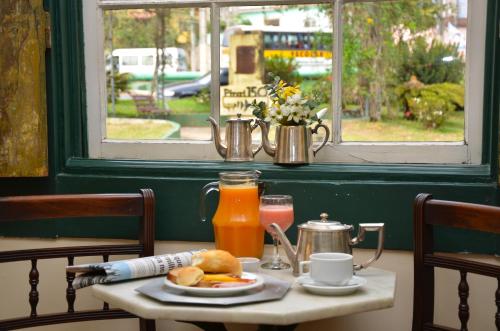 a table with a plate of food and orange juice at Casa do Manequinho Hotel e Restaurante in Piraí