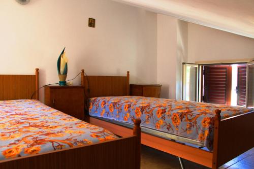 トロペアにあるAppartamento Indacoのベッドルーム1室(ベッド2台、窓付)