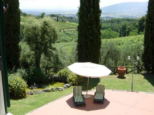 a table and two chairs and an umbrella on a patio at Villa La Nina in Montecarlo
