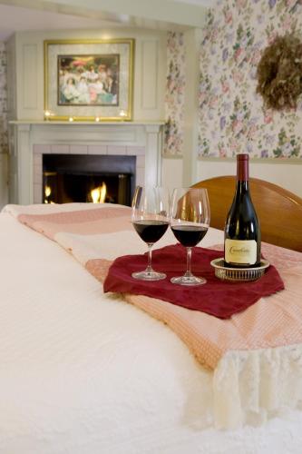 two glasses of wine on a table with a bottle of wine at Rabbit Hill Inn in Lower Waterford