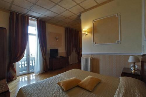 a bedroom with a bed with two pillows on it at Grand Hotel Regina Salsomaggiore in Salsomaggiore Terme