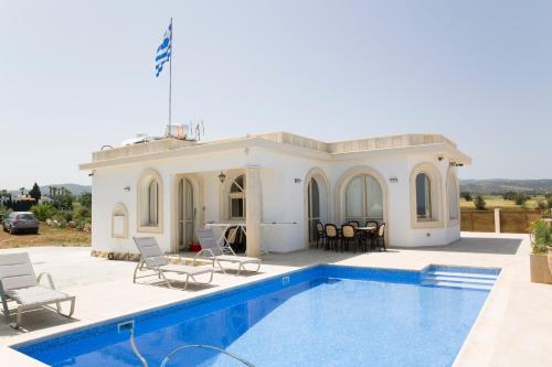 een villa met een zwembad en een huis bij Acropolis Sea View Villa in Polis Chrysochous