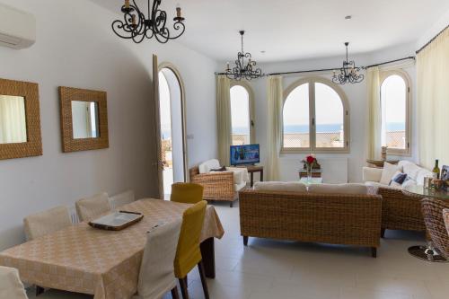 a living room with a couch and a table and chairs at Acropolis Sea View Villa in Polis Chrysochous