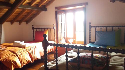 1 dormitorio con 2 camas y ventana en Moradia Rústica Jardim, en Caloura