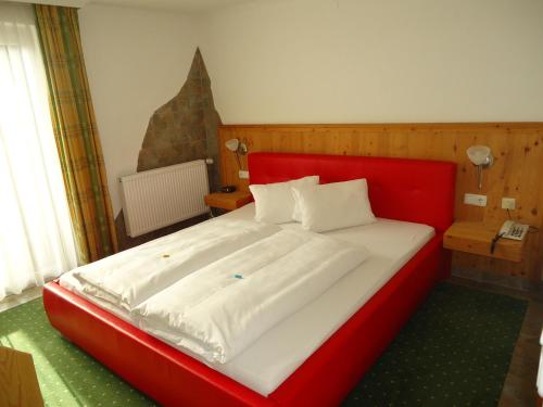 A bed or beds in a room at Hotel Dorfgasthof Schlösslstube
