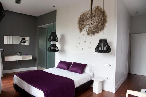 1 dormitorio con 1 cama grande con almohadas moradas en Khu Hotel en Granada