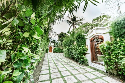 a garden path in front of a house at Villa Frangipani in Sanur