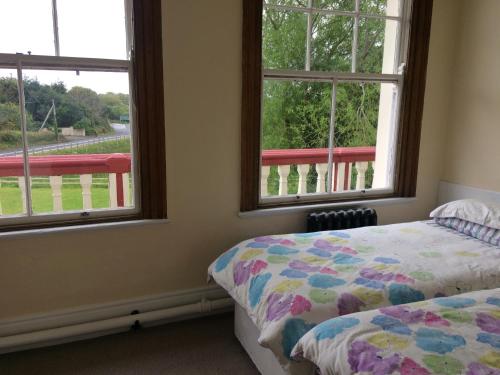 a bedroom with two windows and a bed in it at Staigue Fort House in Caherdaniel