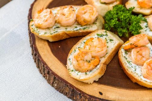 a plate of shrimp sandwiches on a wooden plate at Cielo Maya Beach Tulum in Tulum