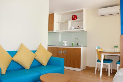 a living room with a blue couch and a table at BX Apartment in Nha Trang