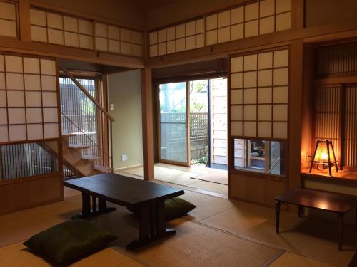 a room with a table in a room with windows at Guest House Kamakura Zen-ji in Kamakura