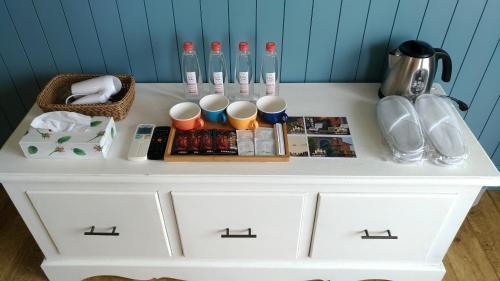 a white cabinet with cups and other items on it at Charmole in Wujie