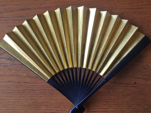 a black fan sitting on top of a wooden table at kinugawaonsen Fukumatsu in Nikko