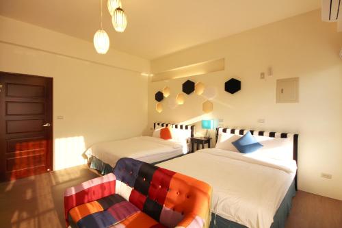 a bedroom with two beds and a couch at 艾希兒民宿 I'm Here hostel l小家庭包棟首選l 台東包棟 l台東火車站l背包單人 in Taitung City
