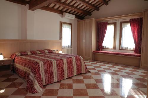 1 dormitorio con 1 cama y suelo a cuadros en B&B Villa Carli, en Caneva