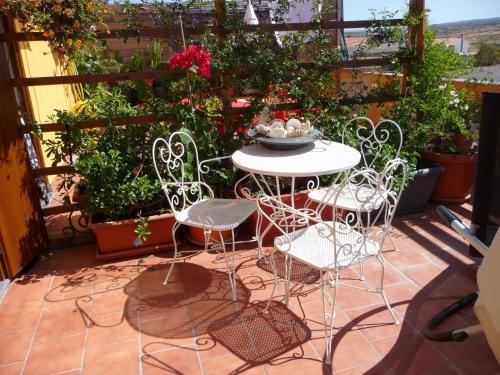 a patio with a table and chairs and plants at B&B Tredomus in Tresnuraghes